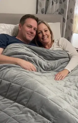 Couple under a Velin weighted blanket